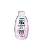 Garnier Ultra Doux rice water shampoo bottle, 400ml, with a clean label and white cap, showcasing nourishing hair care.